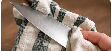 Wiping a chef's knife dry with a cloth